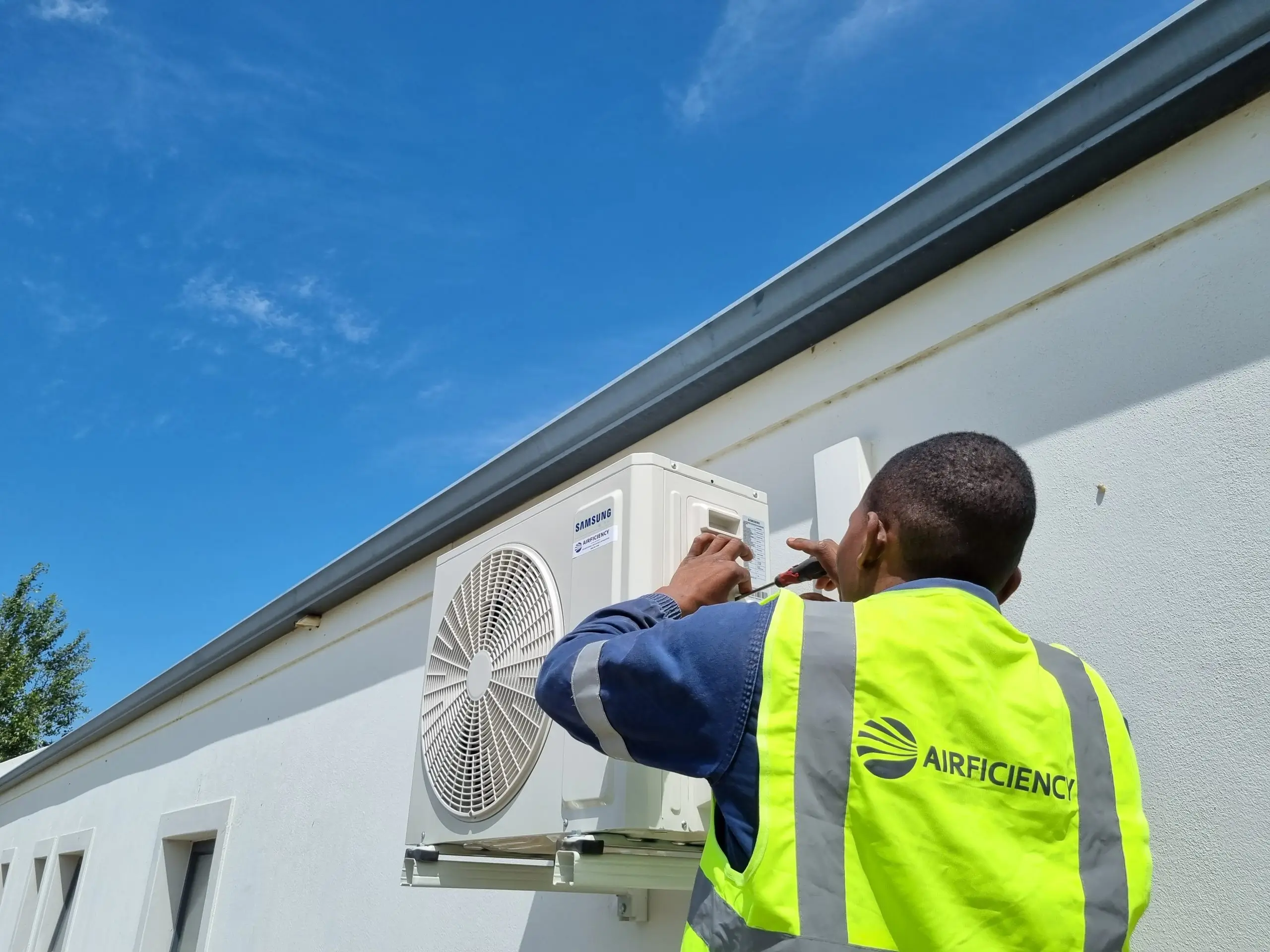 Professional HVAC technician installing wall-mounted air conditioner